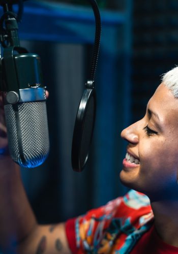 Young professional female singer recording a new song album inside music production studio